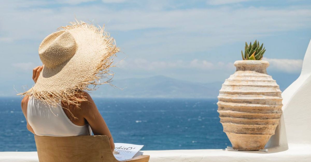 Private sunset gathering at a luxury villa in Mykonos overlooking the Aegean Sea, capturing the essence of off-market travel and discreet high-end experiences.